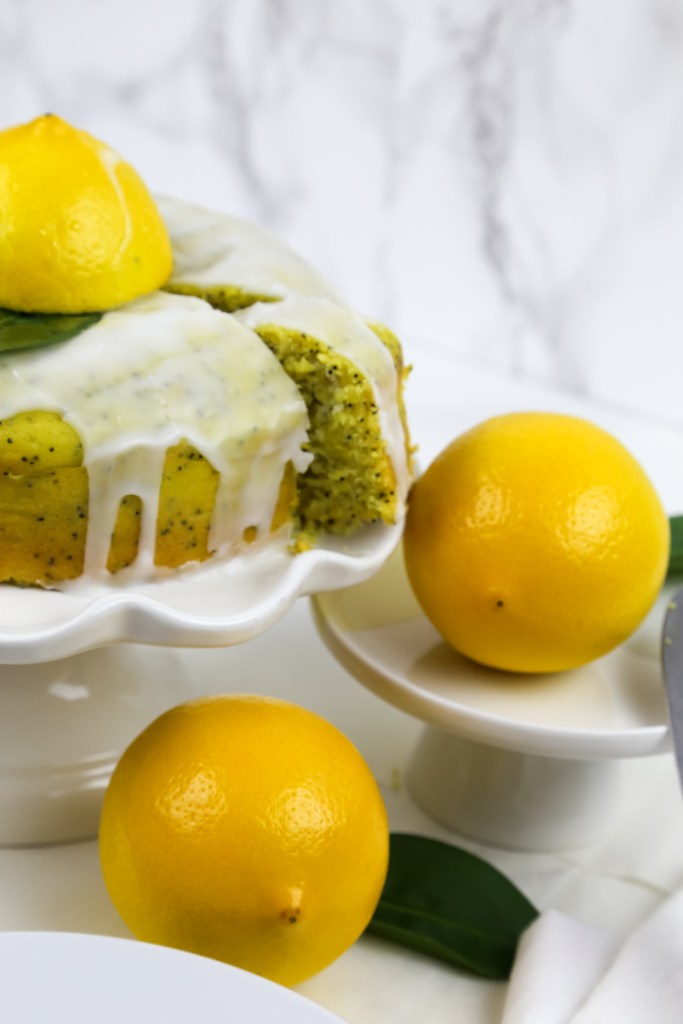 a cake stand with vegan lemon drizzle cake 