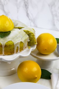 a cake stand with vegan lemon drizzle cake and lemons